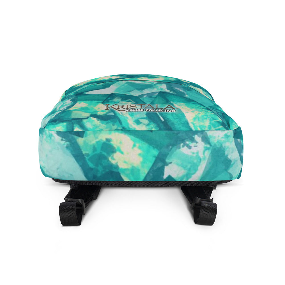head-on view of bottom of all-over teal blue crystal patterned backpack with the kristala game kawaii collection logo across the bottom of the front of the backpack black straps white background
